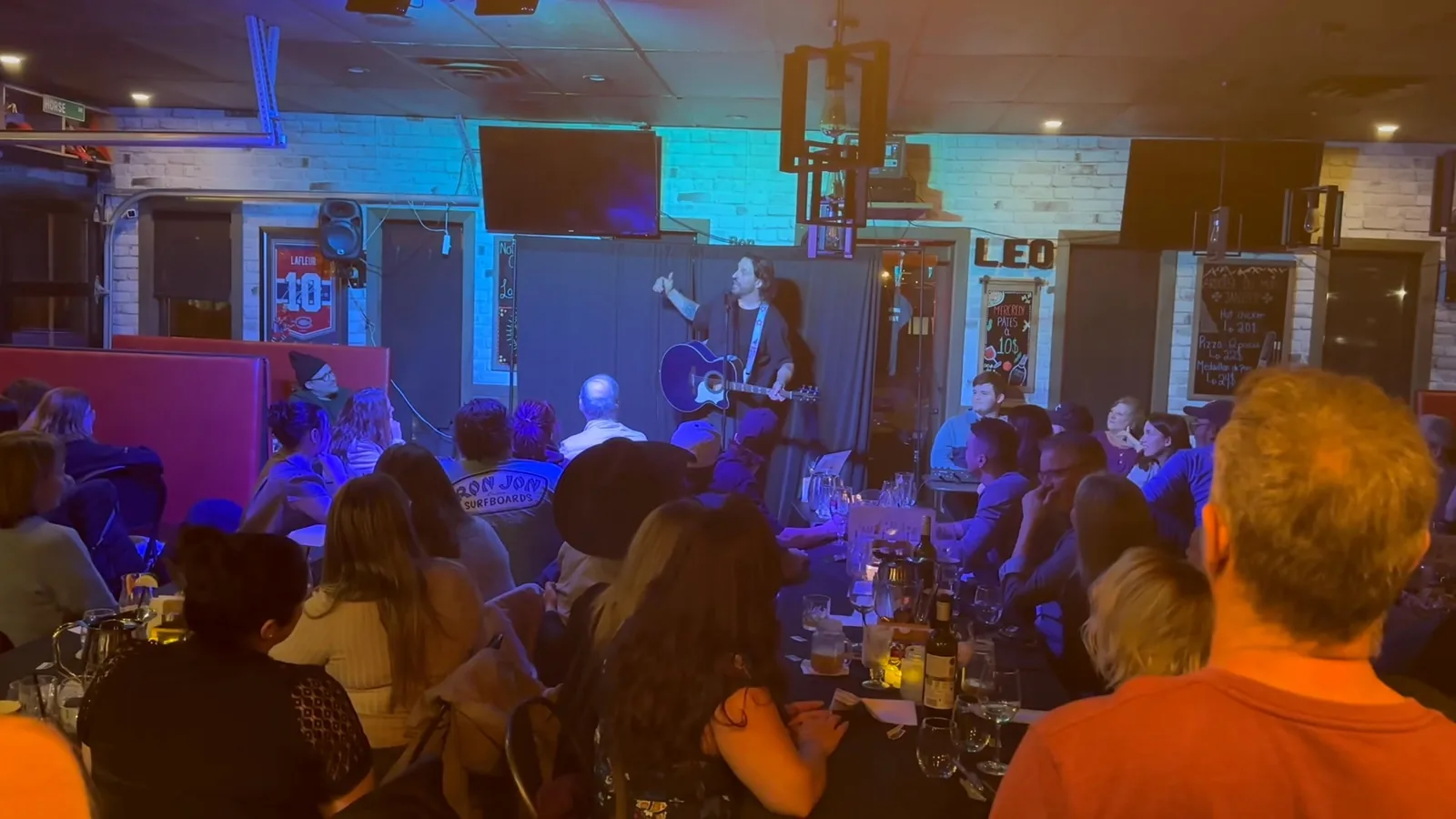 Spectacle en salle au Café Bistro Léo, enseigne LÉO au mur